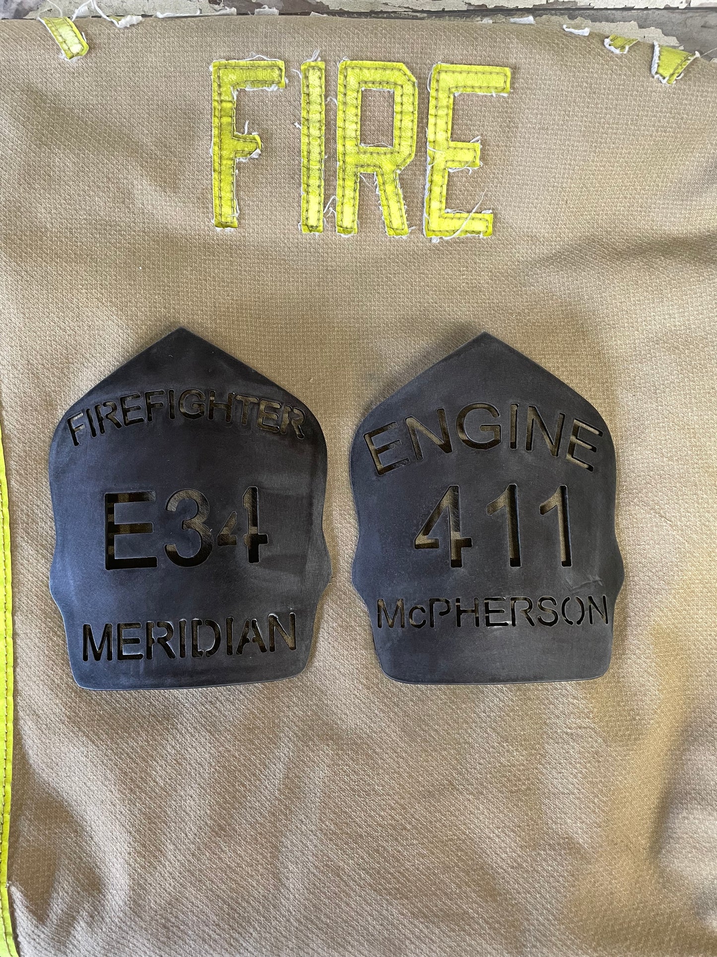 "Custom patina black metal firefighter helmet shield, personalized with department name, unit number, and firefighter name, featuring a durable and unique finish ideal for professional firefighter gear."