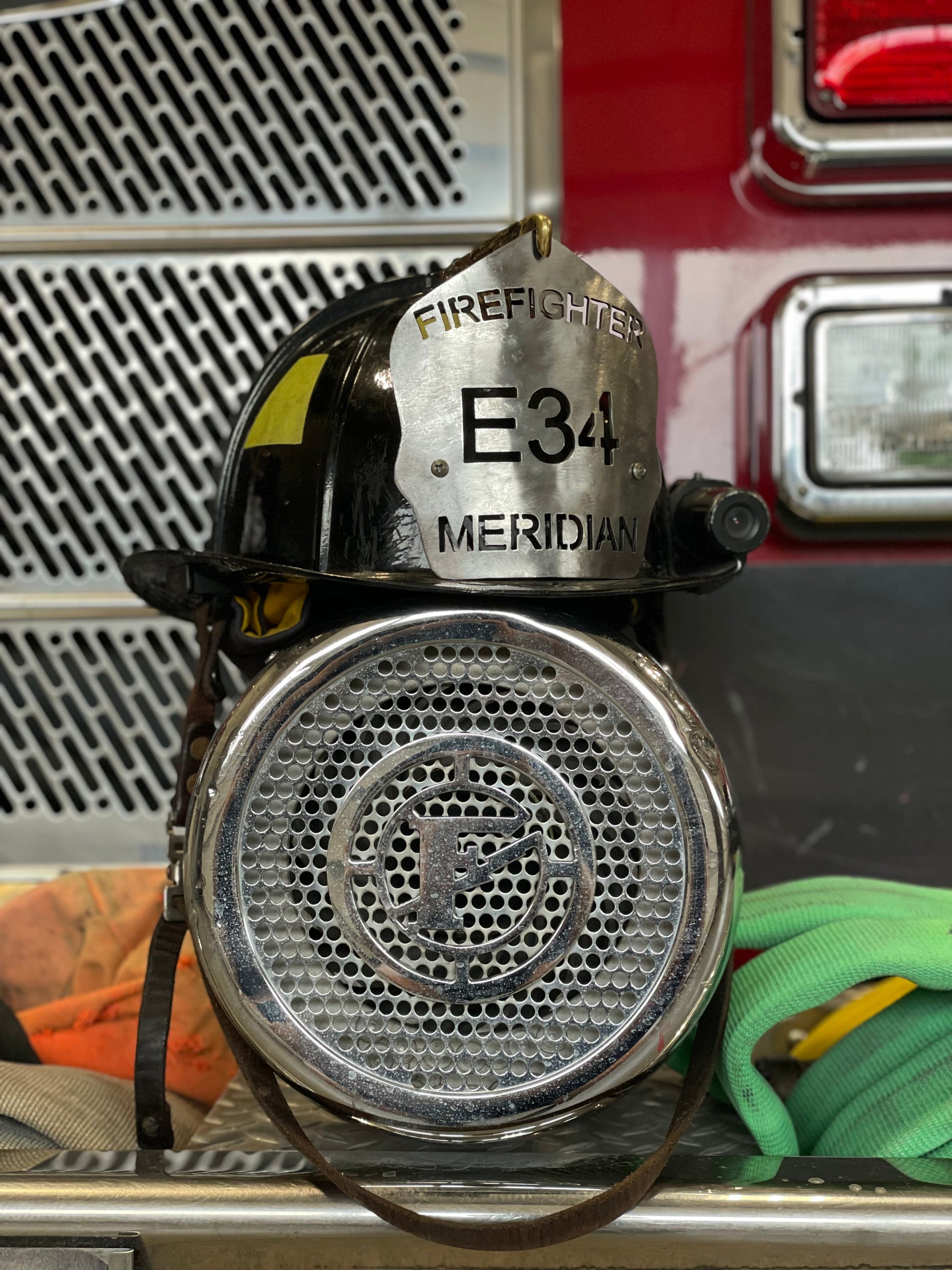 "Custom traditional raw metal firefighter helmet shield with personalized engravings, featuring a classic, rugged design ideal for displaying department name, unit number, and firefighter name."