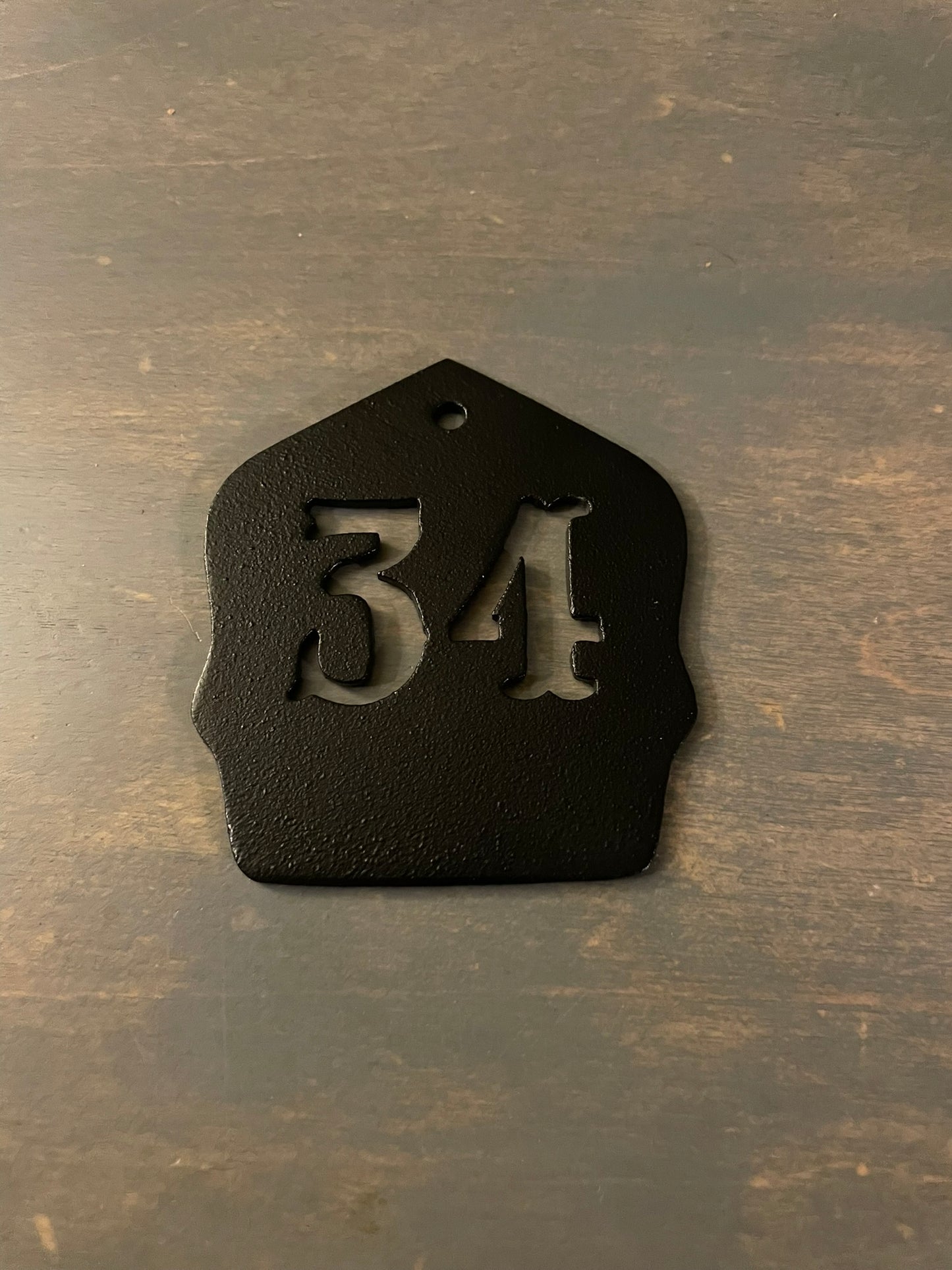 "Black powder coated firefighter helmet shield keychain with personalized unit number, durable custom accessory for firefighters, ideal for keys or gear with sleek, professional finish."