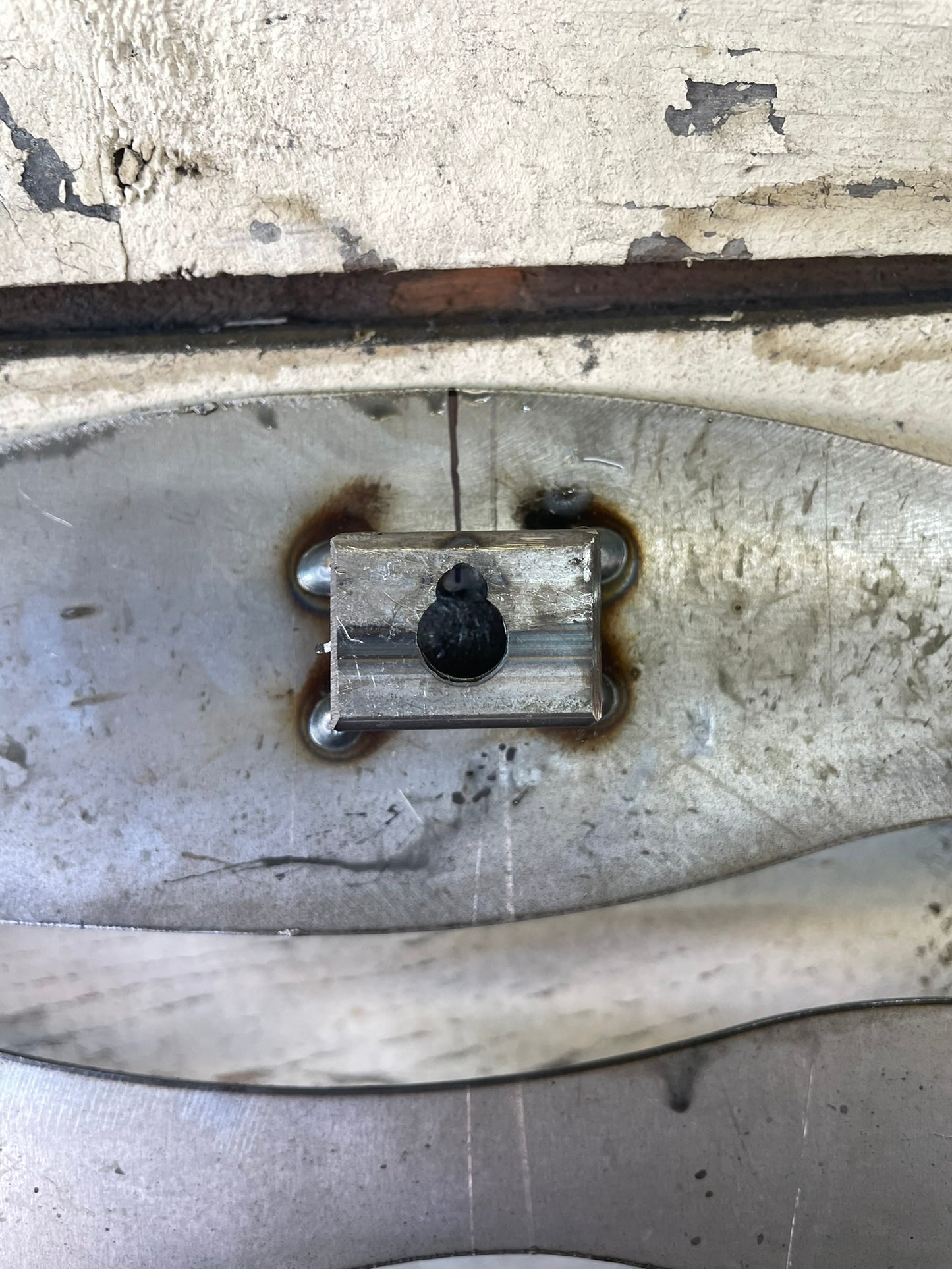 "Closeup photo of welded mounting brackets on the backside of a metal sign, showcasing strong and durable construction for easy and secure wall installation."