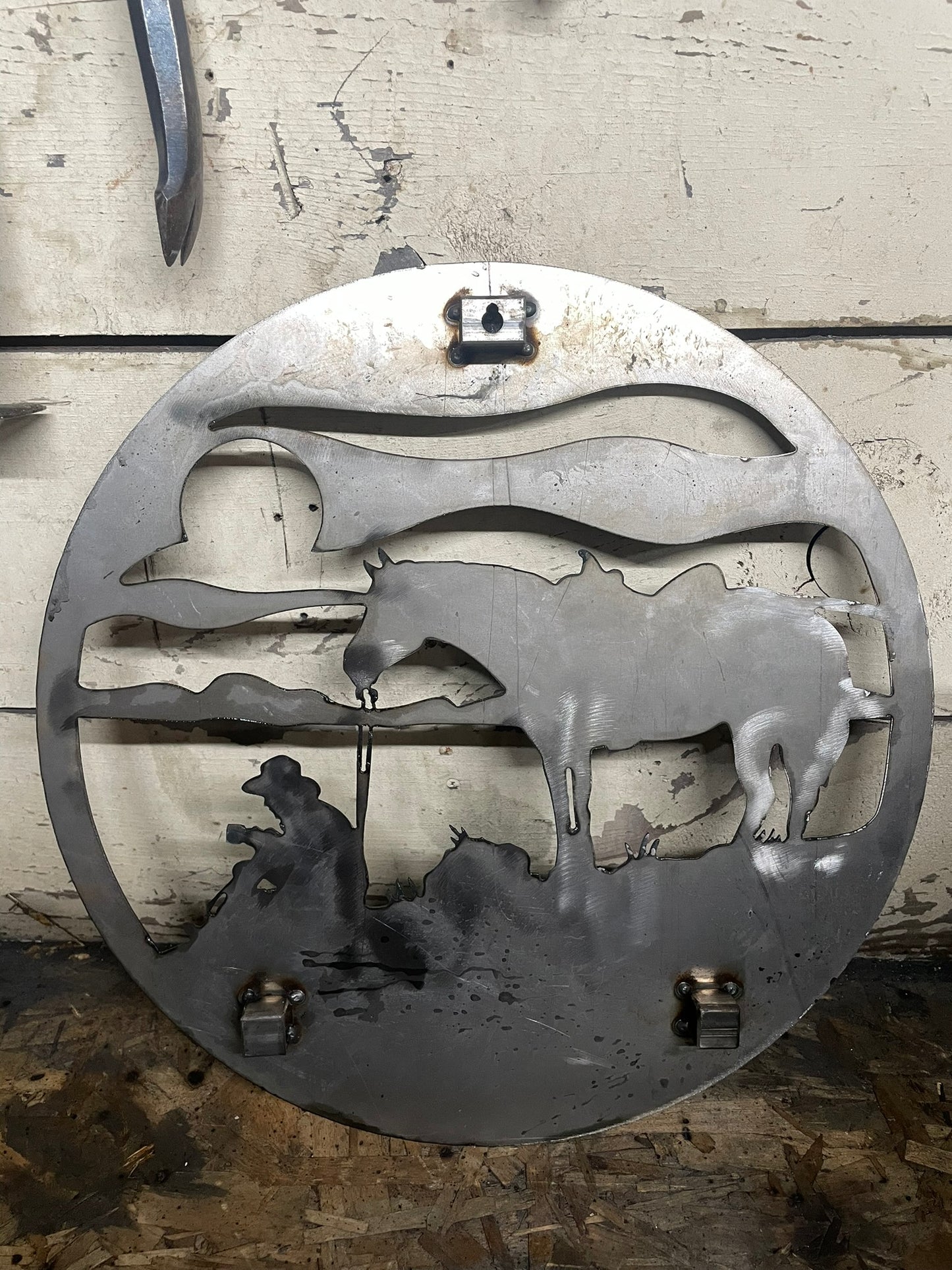 "Back of round metal sign showing welded mounting brackets for secure installation, durable design for easy hanging, ideal for outdoor or indoor decor."