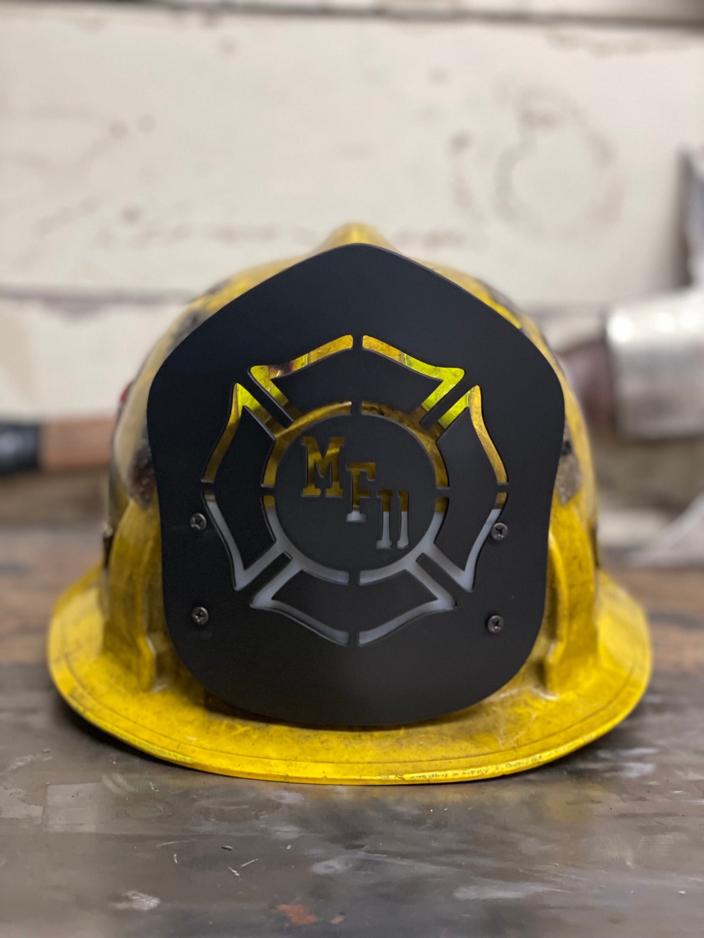 "Custom LA style black metal firefighter helmet shield with personalized engravings, featuring sleek, durable design perfect for displaying department name, unit number, and firefighter name."