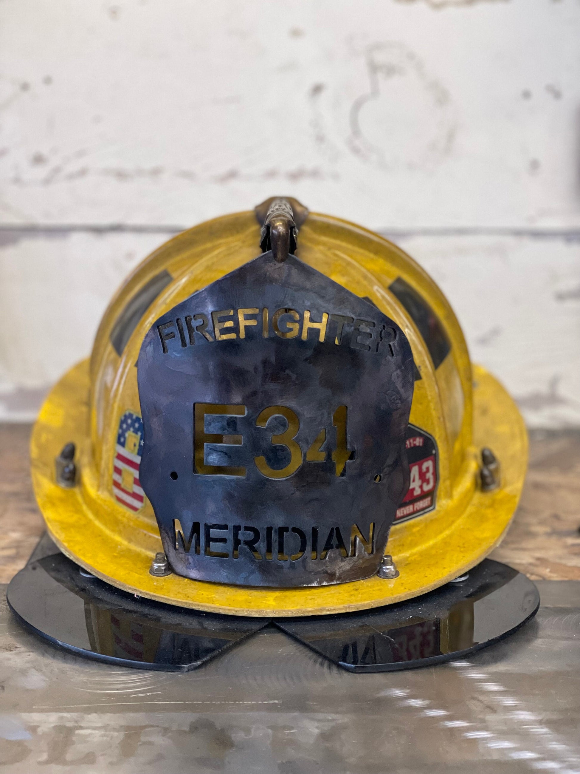 "Custom patina black metal firefighter helmet shield with personalized engravings, durable and unique firefighter accessory, ideal for displaying department name, unit number, and firefighter name."